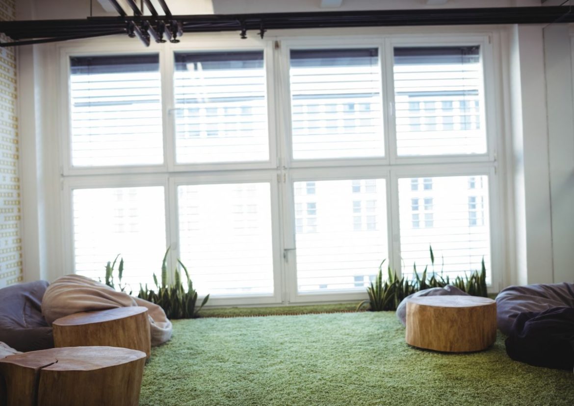 Fenêtre avec store sans vis Grande fenêtre avec des stores vénitiens blancs dans une pièce lumineuse et décontractée.