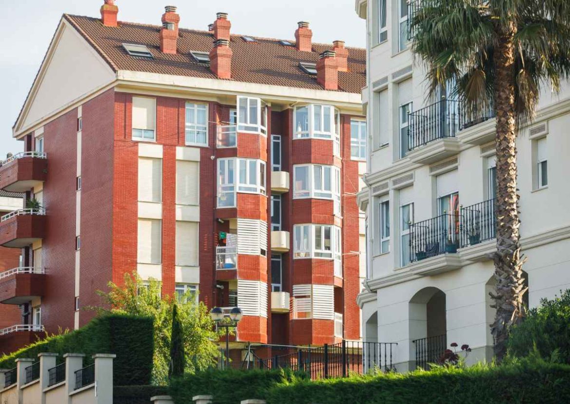 Architecture moderne de l’immobilier neuf. Façades d'immeubles modernes, l'un en briques rouges et l'autre blanc, illustrant l'immobilier neuf.