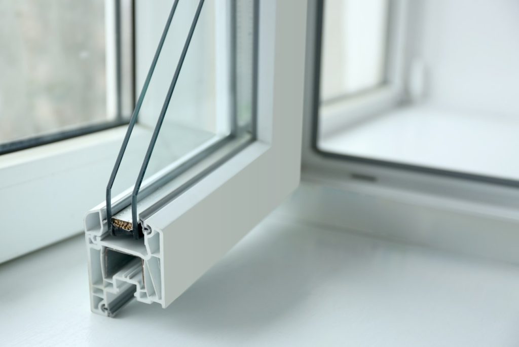 Coupe transversale d'une menuiserie pvc sur mesure prix pas cher montrant le profilé à chambres multiples et le double vitrage.